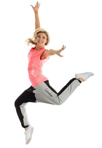 Svetlo roza brezrokavnik in sivi-črni trenirki z logotipom, z sproščenim krojem in gladko teksturo; model v aktivnem položaju.