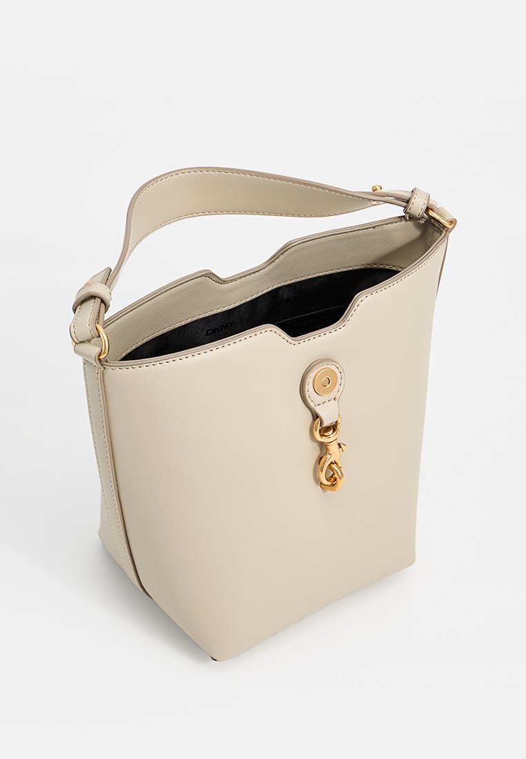 Beige Leder Eimer Tasche mit einer strukturierten Form, gewelltem Rand, verstellbarem Schultergurt und Hardware in Goldfarbe. Das Innere verfügt über eine schwarze Fütterung.