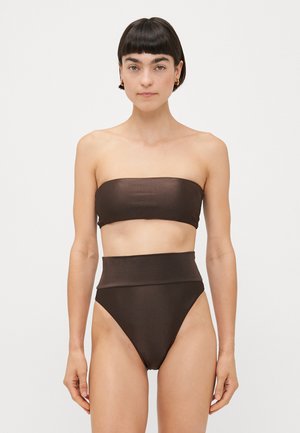 Ruskea bandeau-bikiniyläosa, jossa on sileä pinta, yhdistettynä korkeavyötäröisiin bikinituoleihin, joissa on samanlainen viimeistely ja leikkaus.