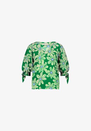 Grüne Bluse mit floralem Muster, das in hellgrün und blauen Blumen gestaltet ist. Sie hat Puffärmel mit Bindebändern an den Manschetten.