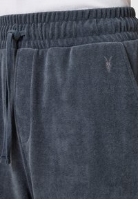 Donkerblauwe sweatpants gemaakt van zachte, textuurstof. Voorzien van een elastische tailleband, verstelbaar trekkoord en een klein geborduurd logo.