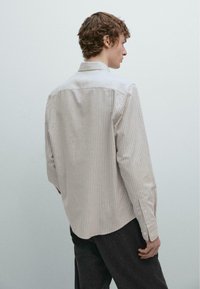 Gestreept shirt met lange mouwen in beige en wit, met een klassieke kraag en knoopsluiting aan de manchetten. Zachte stof met een gladde textuur.