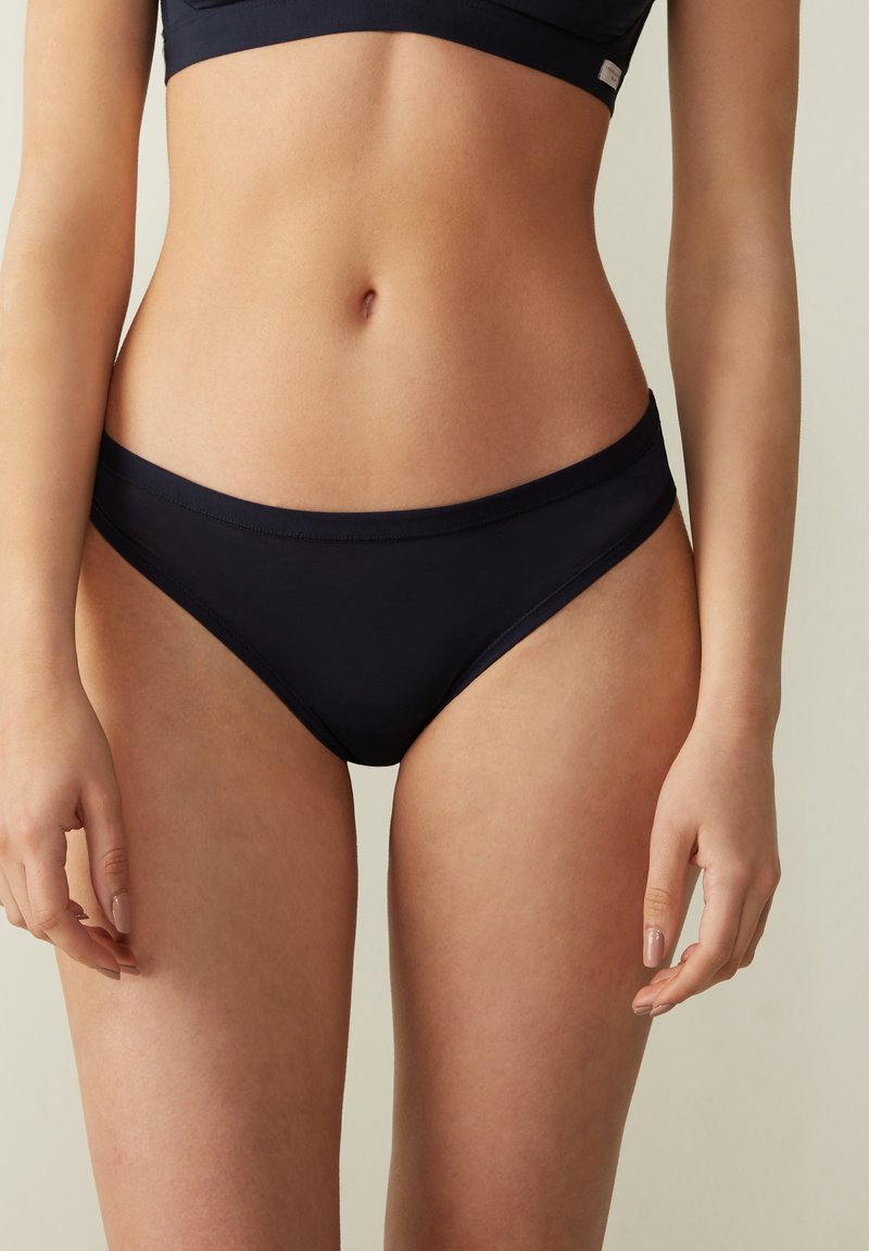 Navyblauwe katoenen bikini onderbroek met een lage taille, een gladde textuur, een elastische tailleband en minimale stiksels voor comfort.
