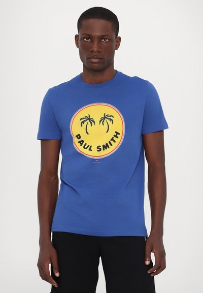 Zila kokvilnas T-krekls ar apļveida grafiku, dzeltena fona, palmām un "PAUL SMITH" tekstu melnā krāsā. Īsās piedurknes, apaļais kakls.