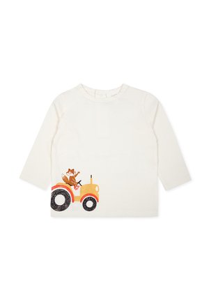 Chemise en coton crème à manches longues présentant un motif de renard marron monté sur un tracteur orange à roues noires sur le côté gauche.