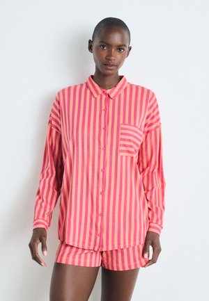 Ensemble de détente rayé rose et orange comprenant une chemise à boutons avec une poche et un short assorti, fabriqué en tissu doux et léger.