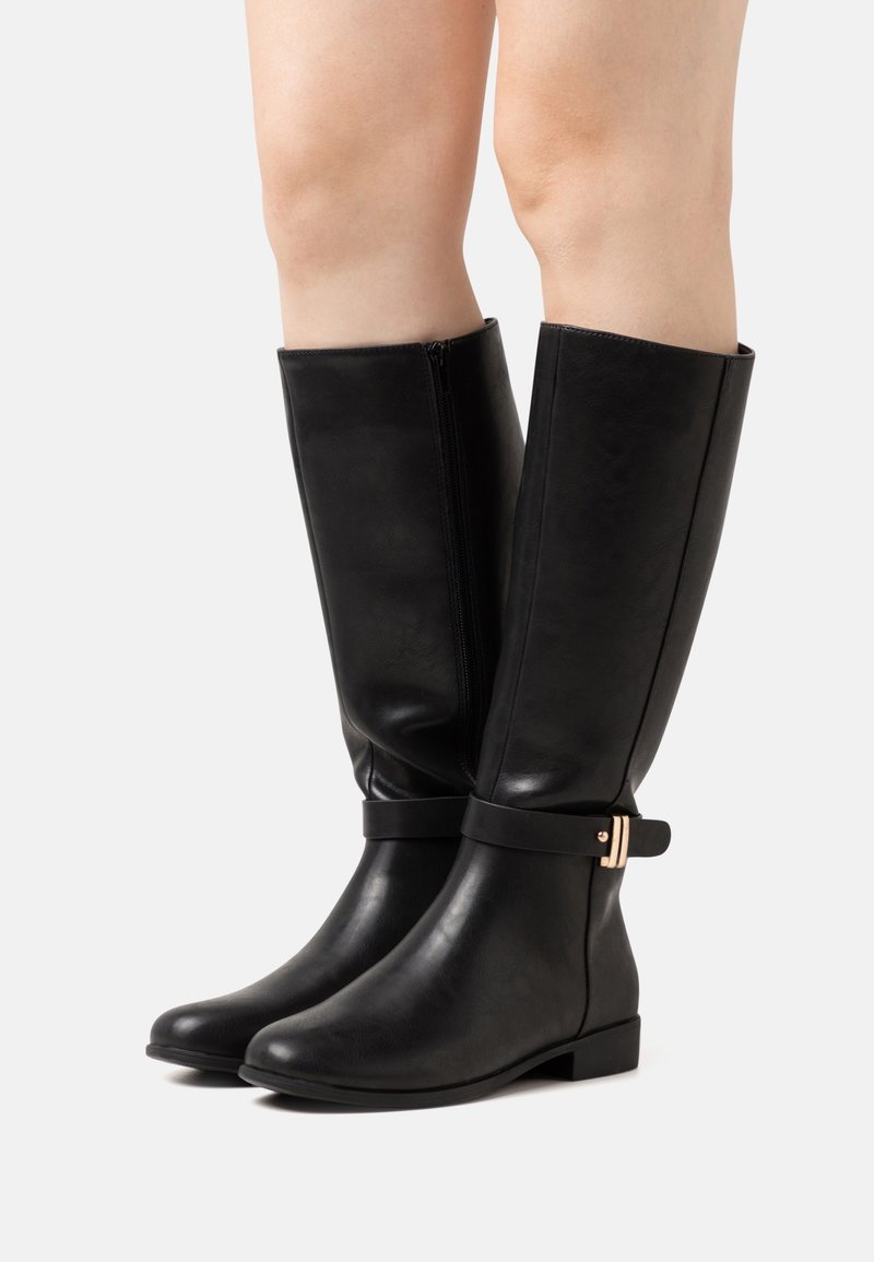 Botas negras de cuero liso hasta la rodilla con suela plana, que presentan una hebilla de acento plateado y una cremallera lateral para facilitar su uso.