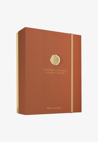 Oransje teksturert boks med et gull-emblem og elastisk lukking. Teksten sier "Et liv fylt med under er et vidunderlig liv." Gull detaljer nedenfor.