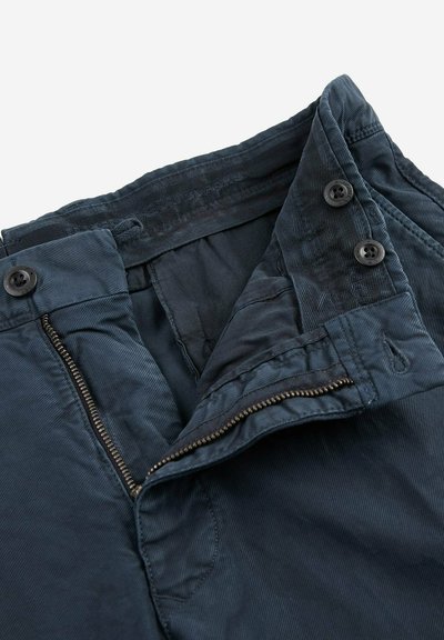 Pantaloni in corduroy blu navy con zip, due bottoni neri in vita e una fodera interna liscia, che mette in mostra una texture a costine.