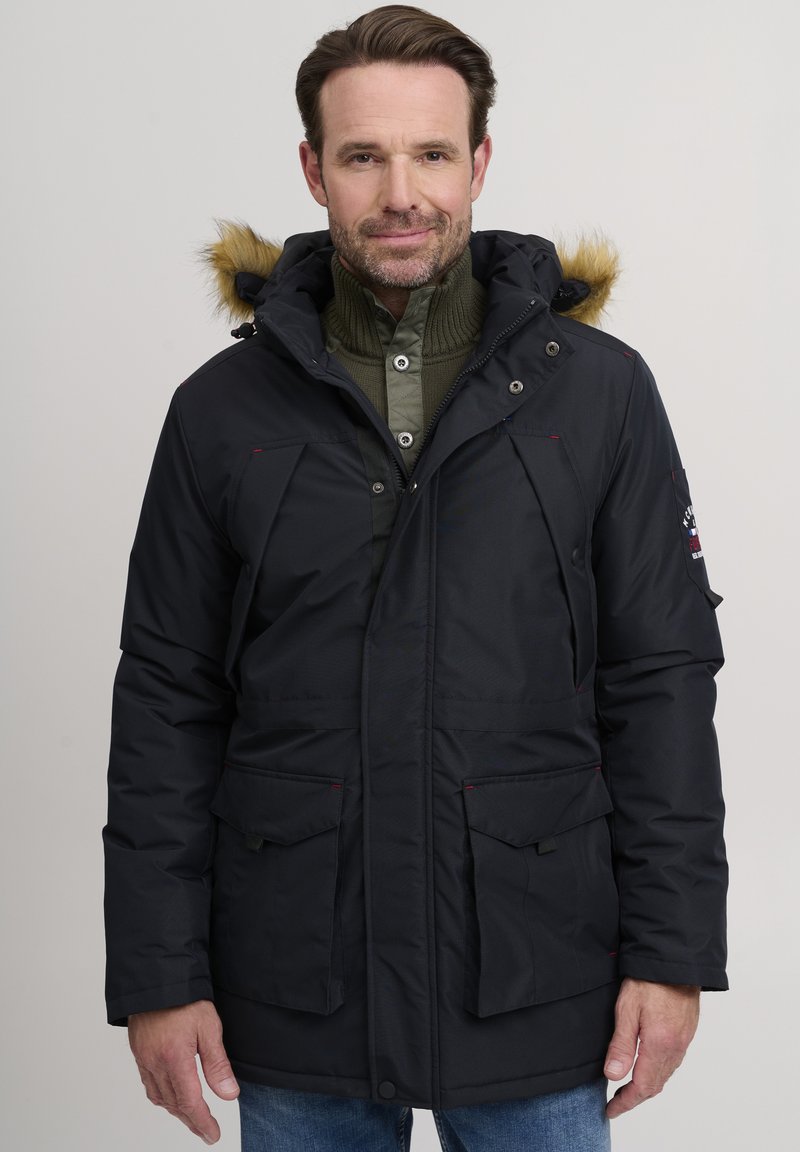 Navy parka jacket with a fur-lined hood, two front patch pockets, elastic cuffs, and a full zipper with snap closure. Textured material.