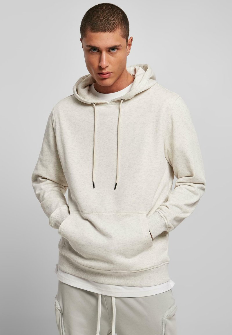 Felpa beige semplice con cappuccio regolabile, tasca a marsupio frontale, maniche lunghe e vestibilità comoda. Tessuto morbido e design minimale.