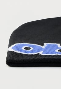 Czarna dziana czapka z mankietem, ozdobiona niebiesko-białym wzorem na przedzie. Miękka w dotyku i elastyczna.