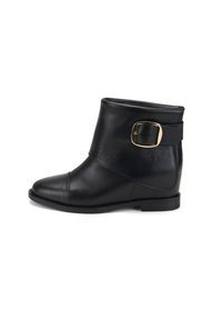 Bottine en cuir noir avec un bout rond, un large revers et une boucle sur le côté. Semelle plate, texture lisse et détail de couture subtil.