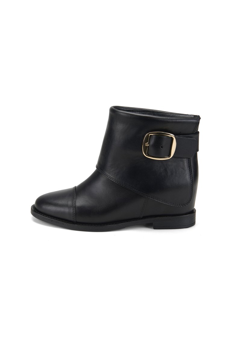 Bottine en cuir noir avec un bout rond, un large revers et une boucle sur le côté. Semelle plate, texture lisse et détail de couture subtil.