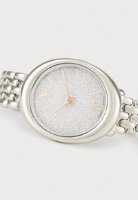 Silver-tone metal watch with a textured white face, rose gold hour markers, and a linked metal bracelet. Features a rounded case design.