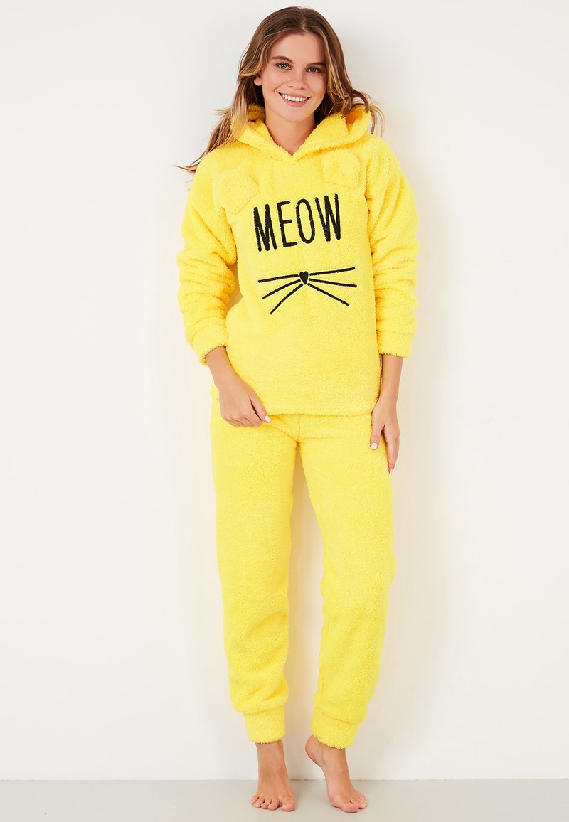 Set de loungewear galben din fleece, compus dintr-un tricou cu glugă care are urechi, text "MEOW" pe față și mustăți, asortat cu pantaloni tapered.