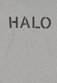 Gråt stof med ordet "HALO" trykt i sort med en minimalistisk skrifttype med stiliserede bogstavformer.