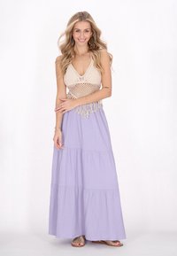 Lyse lilla maxi kjole med lagdelte lag, tekstureret stof og en beige hæklede crop top med halterneck og frynsedetaljer.