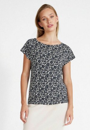 Top a maniche corte con un motivo floreale blu navy su fondo crema. Tessuto leggero, vestibilità rilassata, scollatura rotonda e una texture morbida.