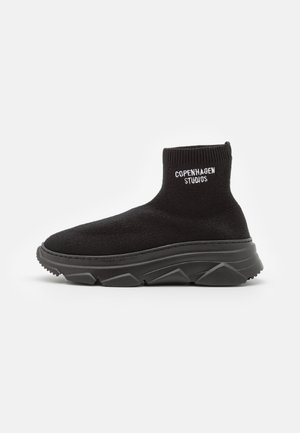 Sort sokkelignende sneaker med tyk tekstureret sål og "Copenhagen Studios" logo på ankelsuffen, vist fra siden på hvid baggrund.