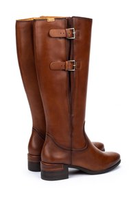 Bottes en cuir marron tall avec deux sangles à boucles réglables et des talons bas empilés, présentées côte à côte sur fond blanc.
