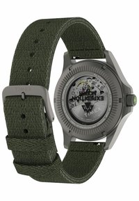 Timex-ur med grøn flettet nylonrem, titaniumkasse og en grå urskive, der viser et automatisk urværk og synlige mekaniske dele.