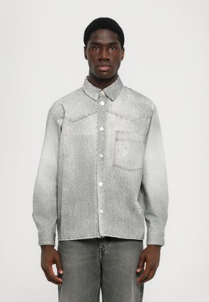 Gray denim shirt with a button-down design, chest pocket, and distressed accents, featuring a slightly faded texture and long sleeves.
