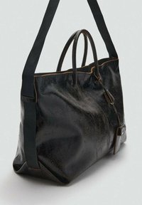 Borsa in pelle nera con una finitura lucida, dotata di due manici robusti e una tracolla rimovibile. Accentuata da cuciture marroni.