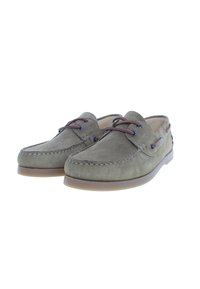 Scarpe da barca in suede verde oliva con lacci marroni, dettagli di cucitura e punta rotonda. Presentano una suola in gomma per una migliore aderenza.
