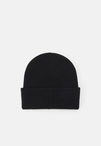 Svart strikket lue med brett, har ribbestruktur og rund topp, egnet for kaldt vær.