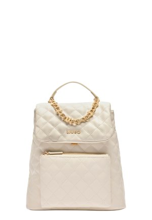 Zaino beige trapuntato con manico a catena dorata e tasca frontale con zip. Presenta una chiusura con patta e logo impresso sul davanti.