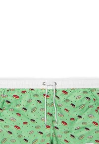 Costumi da bagno verdi con un motivo a ciambelle ripetuto in vari colori, con una vita elastica bianca e dettagli con cordino.