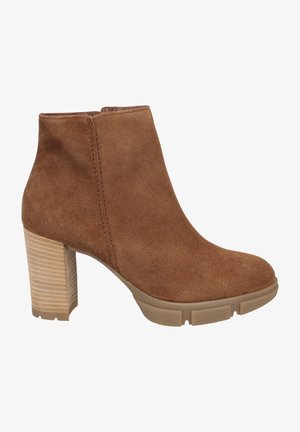 Botín de ante marrón con tacón grueso y base de madera texturizada y estratificada. Superficie suave con detalles de costura a lo largo del costado.