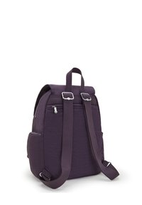 Lila tygryggsäck med rulltoppsdesign, justerbara remmar, framfickor med dragkedja och sidofickor. Slät textur och hållbar hårdvara.