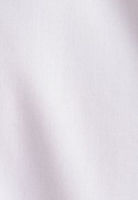 Witte geweven stof met een lichte schaduw aan de linkerkant, waardoor de textuur en het fijne draadmuster zichtbaar zijn.