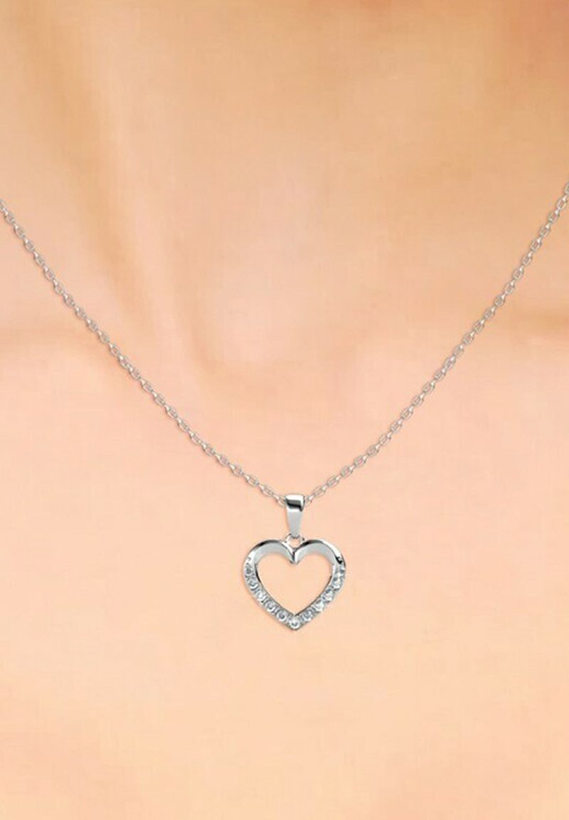 Collana con pendente a forma di cuore in argento, dotata di una catena, con pietre trasparenti attorno al bordo, che mette in evidenza il suo design aperto e la superficie liscia.