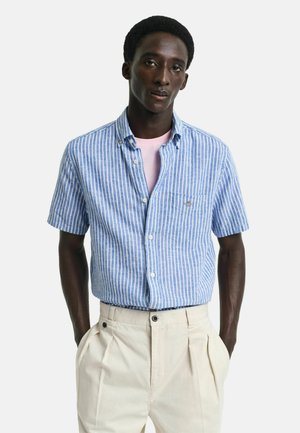 Short-sleeve button-up shirt in light blue and white stripes, made of fabric with a smooth texture; features a chest pocket and collar.