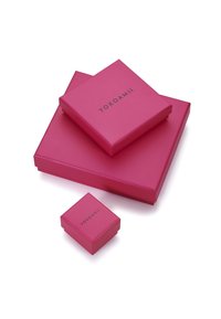 Trois boîtes-cadeaux roses de tailles différentes empilées, présentant une texture lisse et un logo en relief "Yokoamii" sur la surface supérieure.