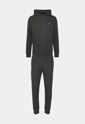 Dark gray hoodie and jogger set made of soft fabric. Hoodie features a kangaroo pocket and drawstring hood; joggers have an elastic waistband.