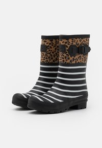 Bottes de pluie en caoutchouc noir avec un haut en imprimé léopard marron et des rayures horizontales noires et blanches sur la partie inférieure. Détail de boucle sur le côté.