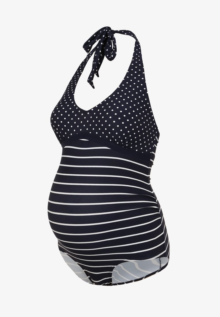 Maiô de maternidade em azul-marinho com bolinhas brancas na parte de cima e riscas horizontais na parte de baixo. Apresenta alças de pescoço estilo halter e tecido elástico.