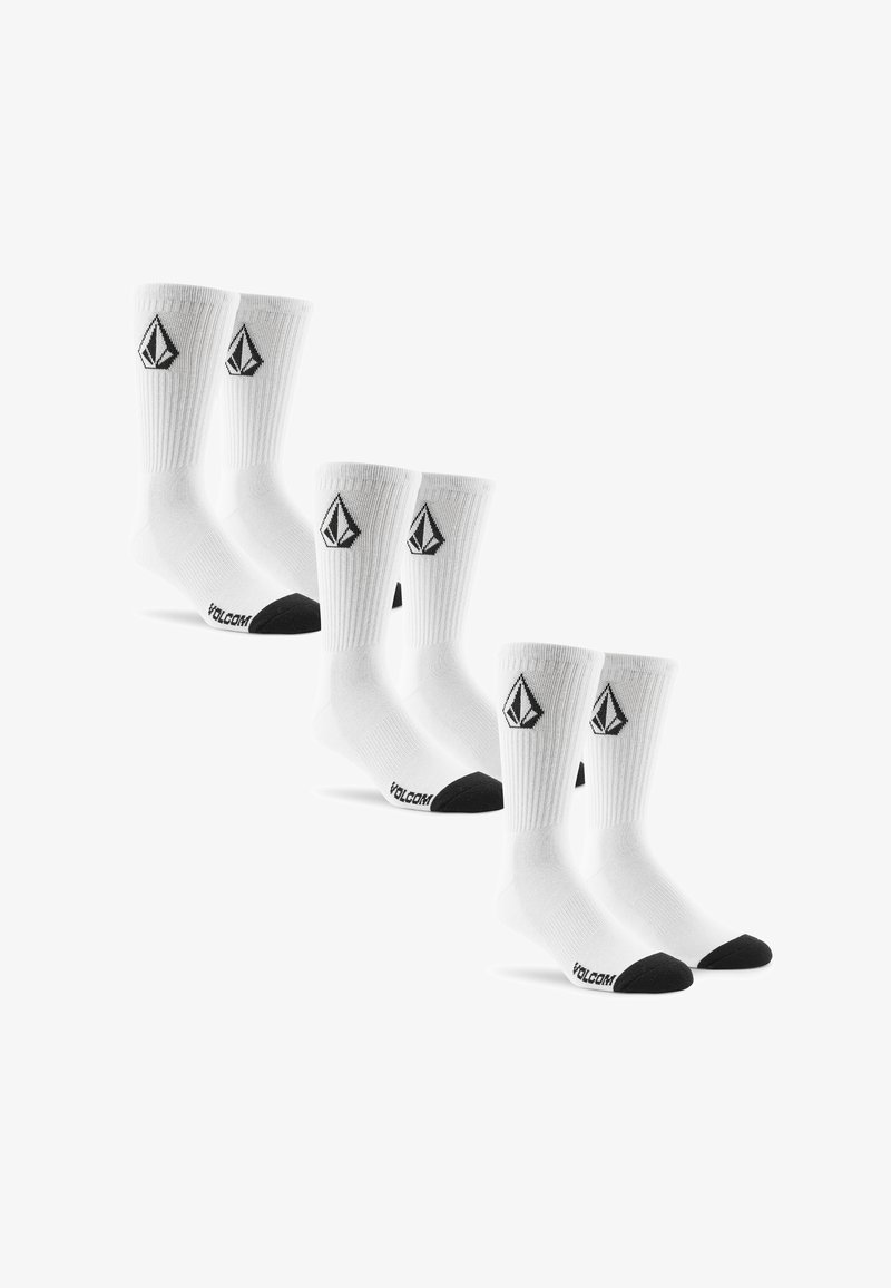 Trois paires de chaussettes montantes blanches avec des orteils et talons noirs, arborant un logo géométrique noir près du haut et le texte "VOLCOM" sur le pied.