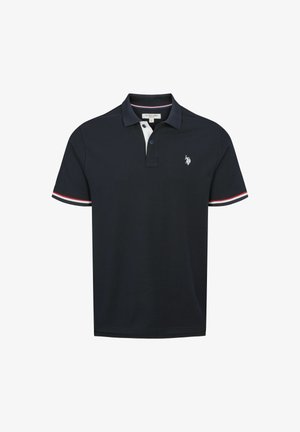 Tummansininen polo-paita, joka on valmistettu puuvillasta, valkoisella kauluksella ja puna-valkoisilla raidoilla hihoissa. Rintakehässä brodeerattu logo.