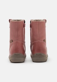 Hnědé kožené kotníkové boty s hladkým povrchem, kontrastními tmavými gumovými podrážkami, bočními zipy a útulným kožíškem na límci.