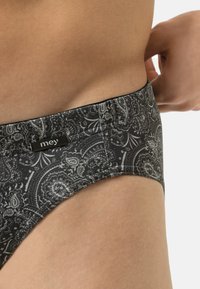 Costume da bagno inferiore nero e grigio con un morbido elastico in vita, che presenta dettagli a paisley intricati e un piccolo etichetta del marchio.