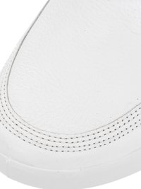 Close-up of white leather sneaker toe with detailed double-row stitching along the edge and textured surface.