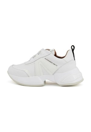 Białe sneakersy z gładką skórzaną cholewką, masywną podeszwą i tonowymi akcentami. Posiadają sznurowanie z przodu oraz czarną pętelkę na pięcie.