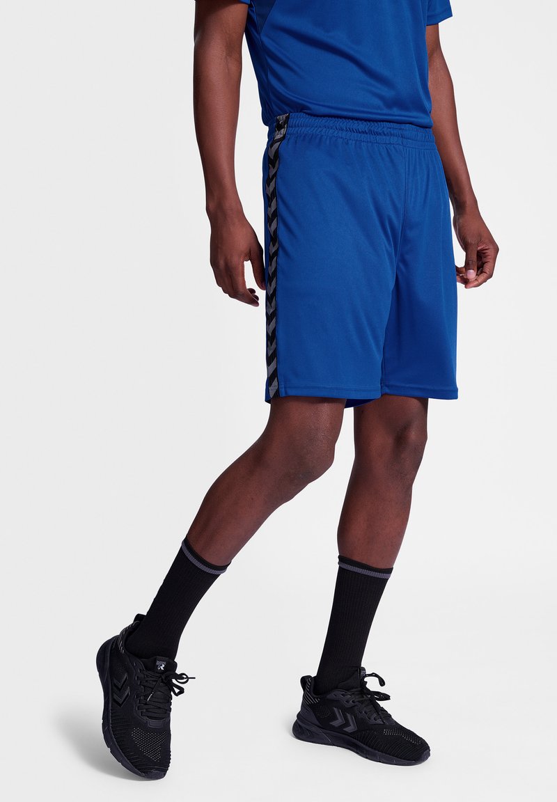 Pantalones cortos deportivos azules hechos de un tejido ligero, con rayas en forma de chevrón negras a los lados, y una cintura elástica para mayor comodidad.