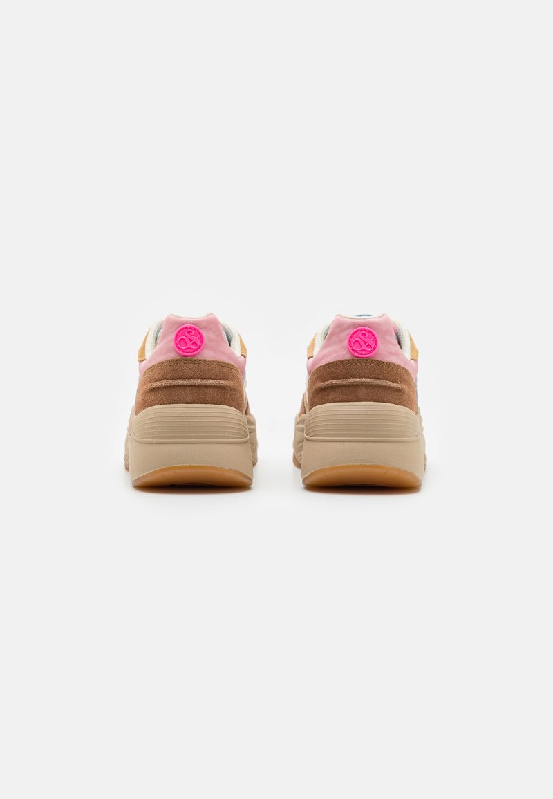 Sneakers met een beige zool, bruine suède zijkanten, roze accenten en een cirkelvormig logo op de achterkant, met een textuur bovenkant en een gevoerde hiel.