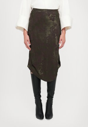 Fustă din satin de culoare verde măslin, cu un model floral, tiv asimetric și fente laterale, asortată cu cizme negre lungi până la genunchi, ajustate.